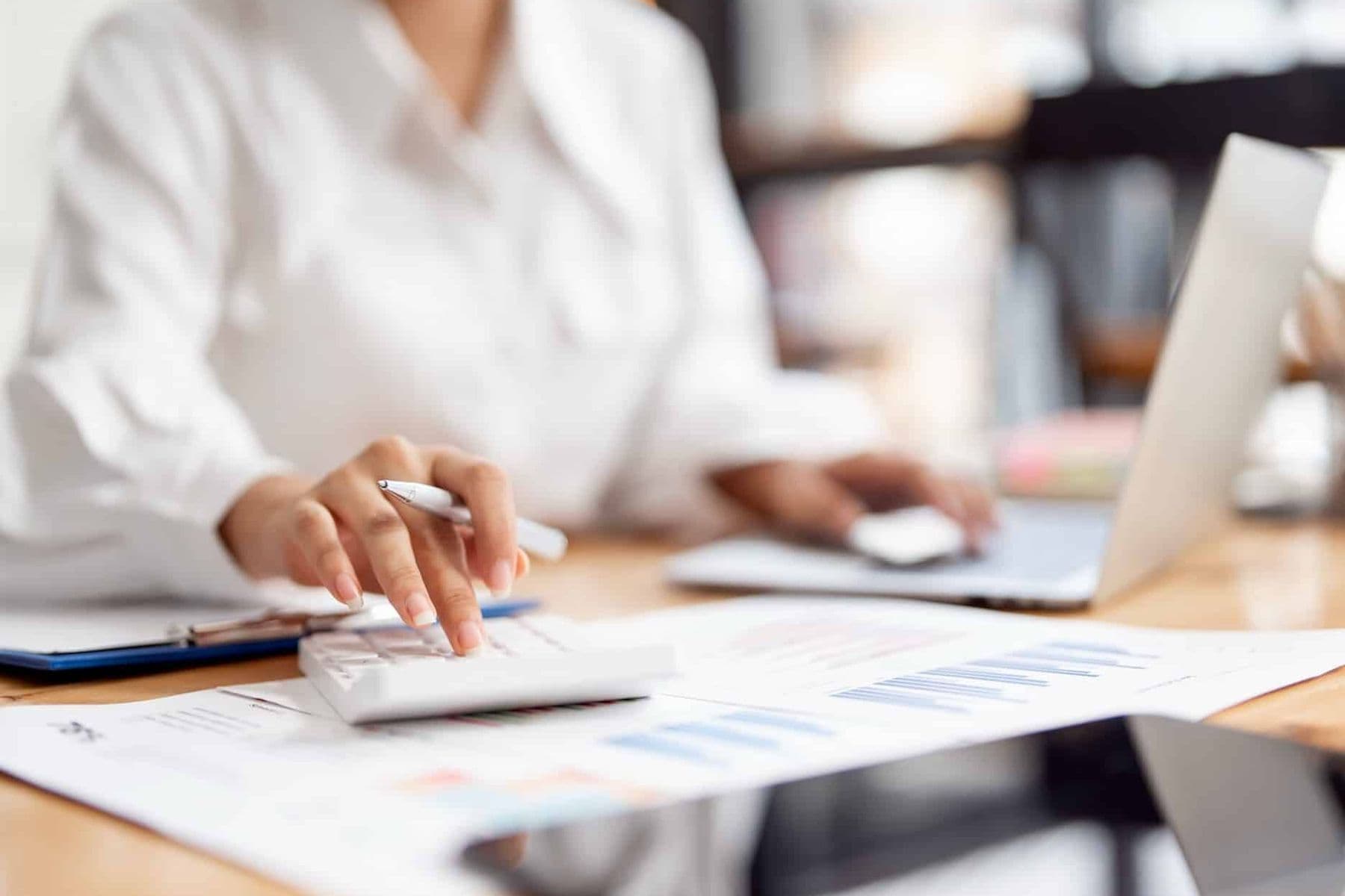 A female accountant applying 'add-back' bad debt relief in the UAE during VAT invoice review.