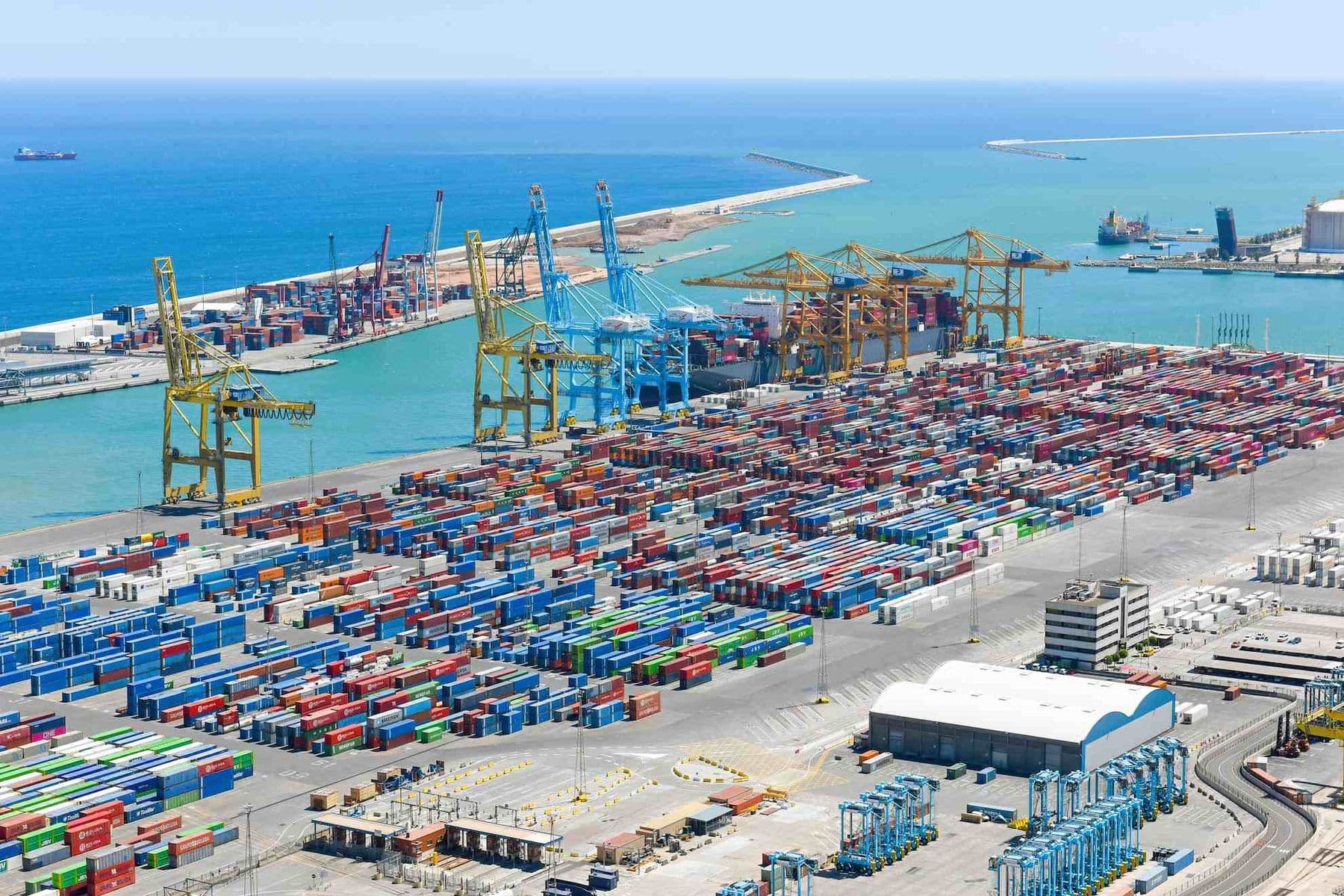 UAE cargo port with shipping containers and cranes showing import of goods subject to UAE excise tax.