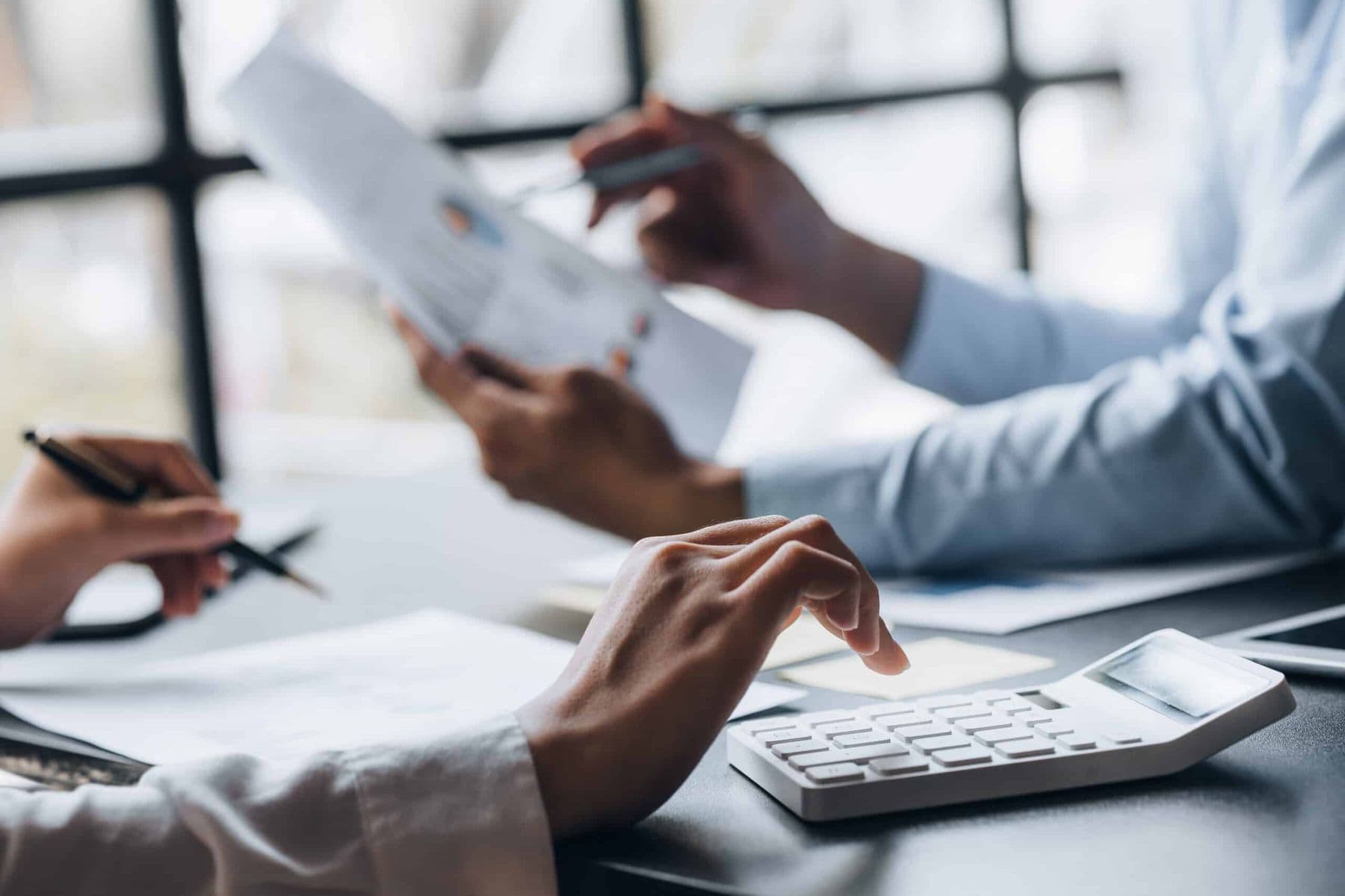 Businessperson reviewing corporate tax documents with calculator to meet UAE filing deadlines and avoid FTA penalties.