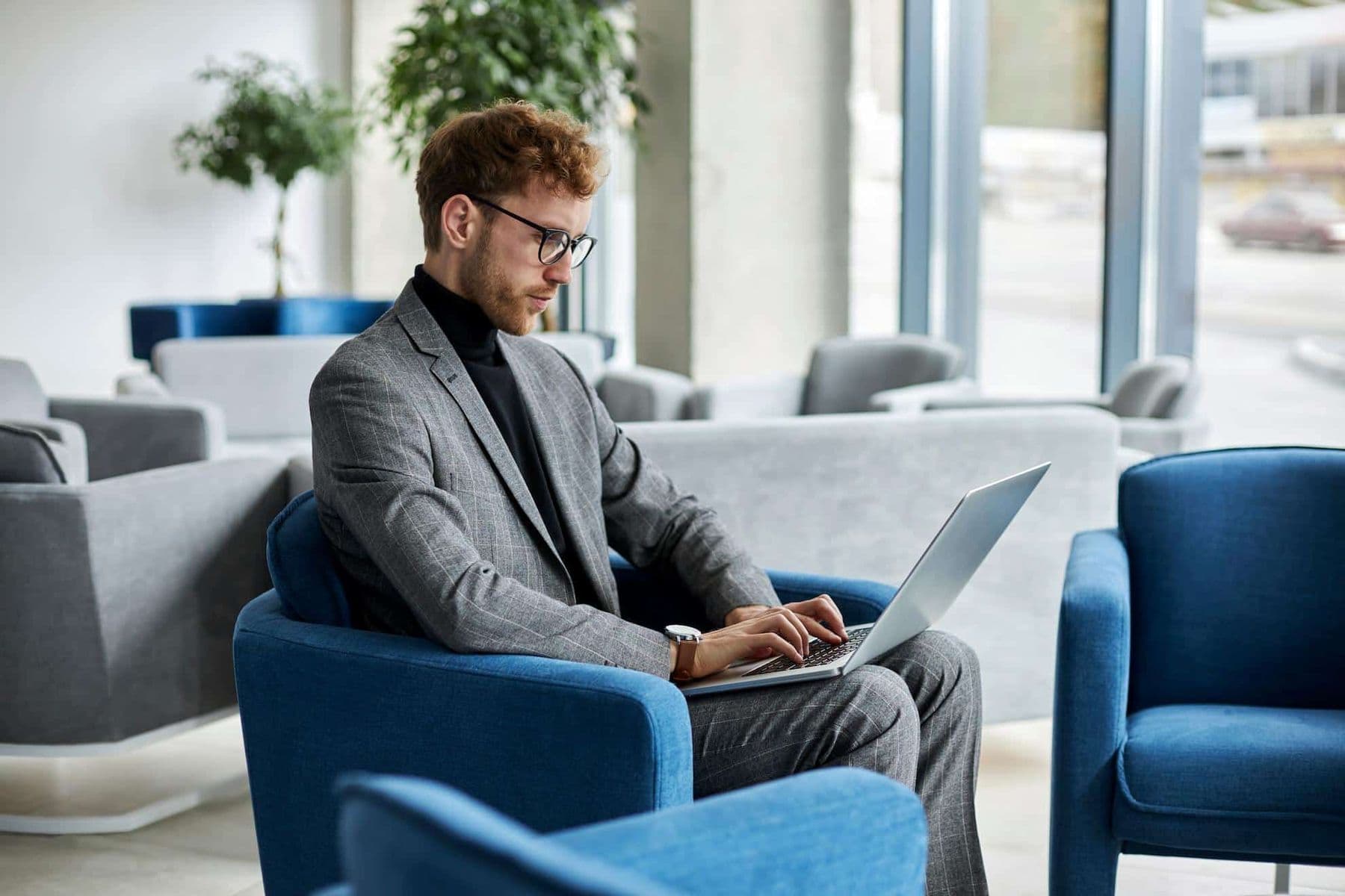 Business professional working on his laptop in a UAE office lounge.