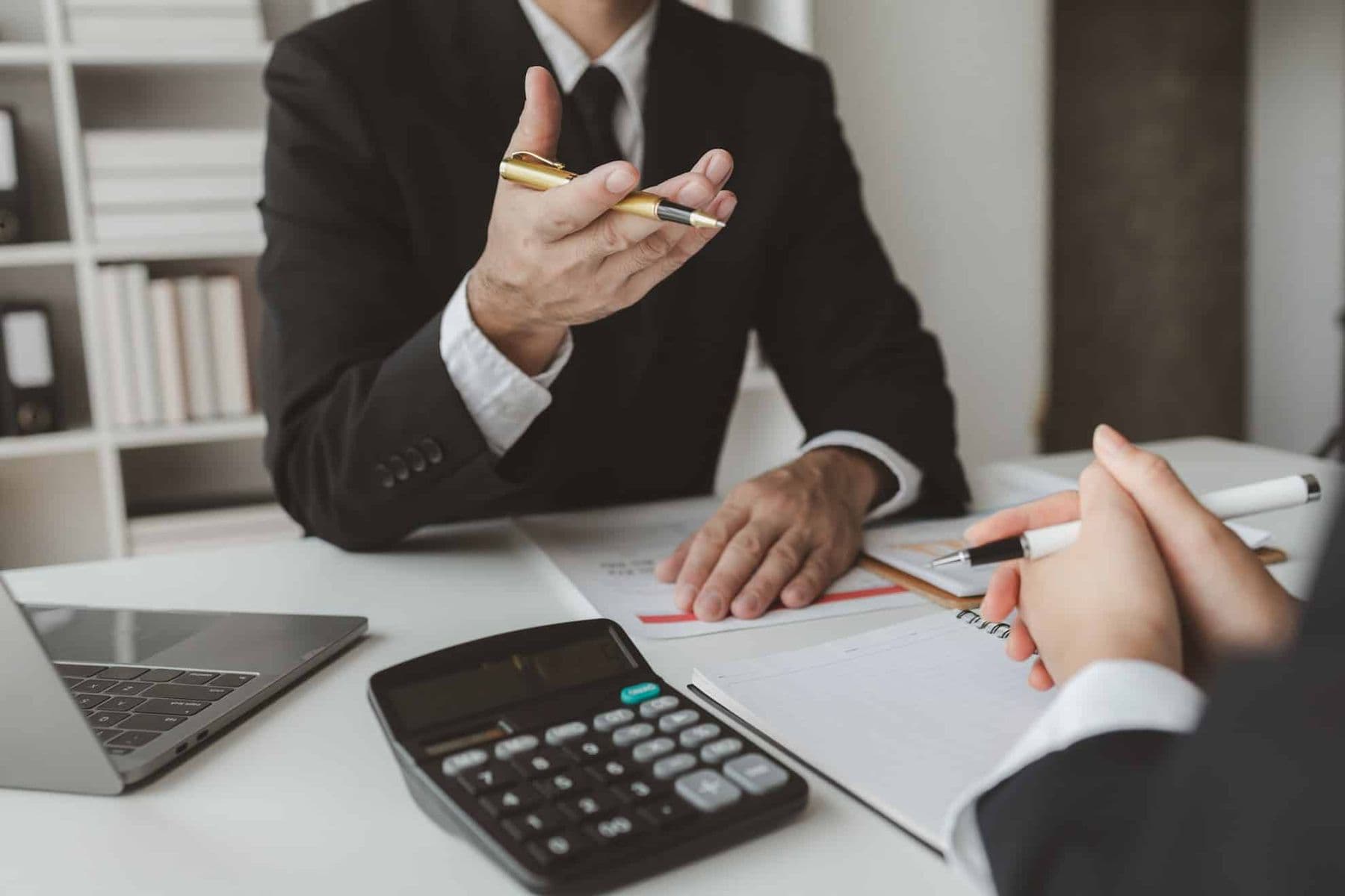 Close-up of a business meeting with a man in a suit explaining VAT filing and payment in the UAE.