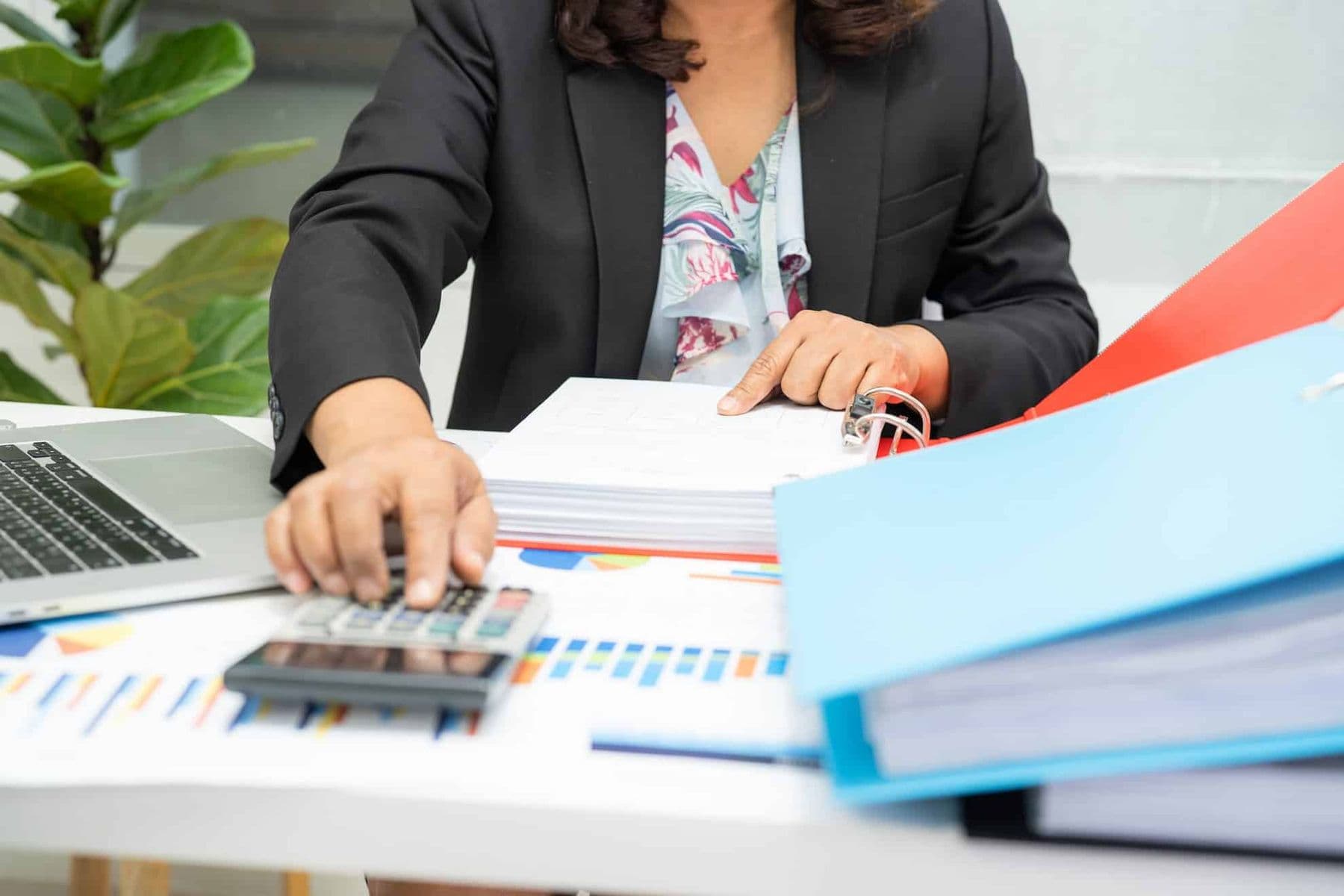 Accountant in the UAE reviewing financial records and calculating business accounts for compliance with bookkeeping requirements under UAE law.