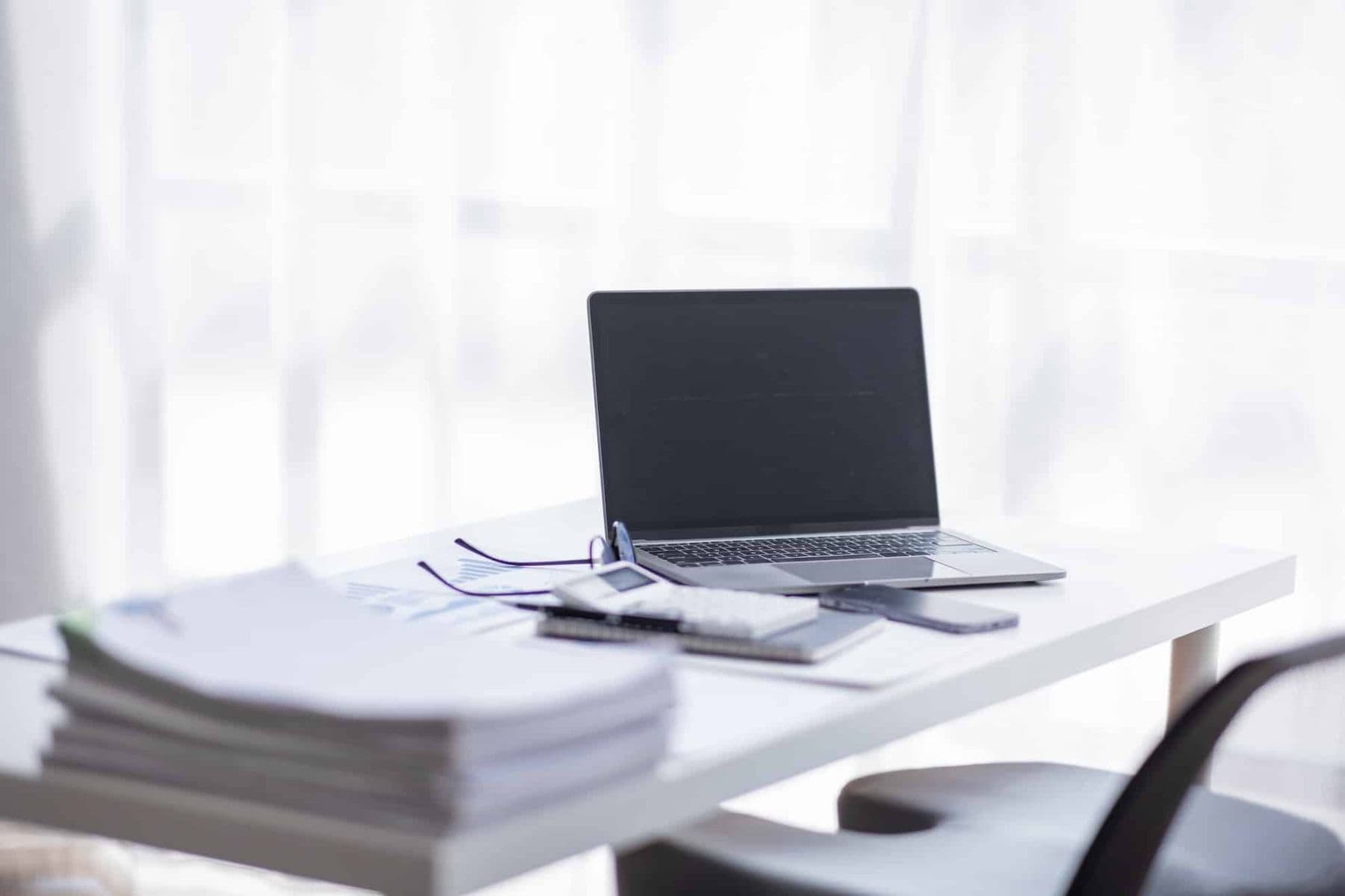 Professional desk setup showing laptop and business documents for creating UAE tax invoice format compliance.