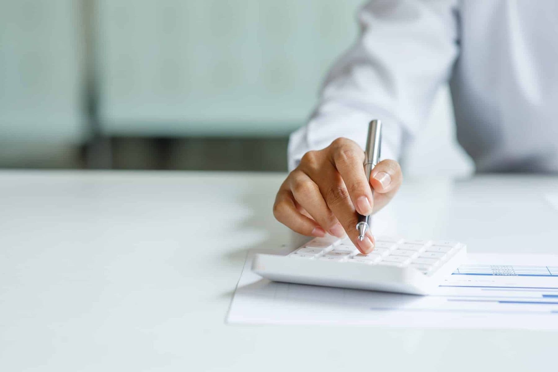 Business professional calculating VAT compliance with documents and a calculator in their office.