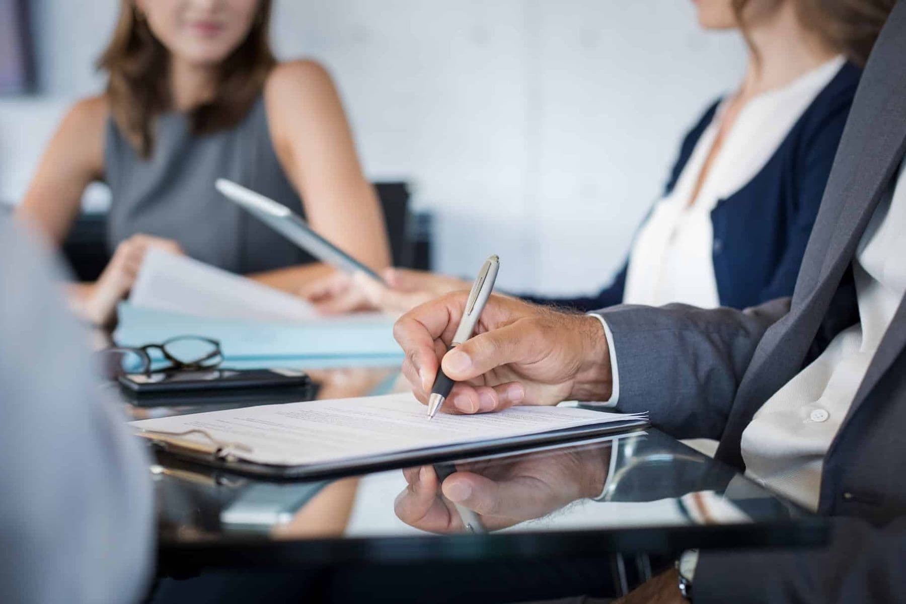 Business professionals reviewing and signing corporate tax registration documents in the UAE.