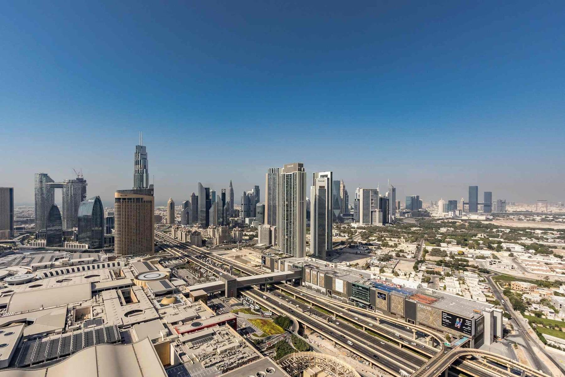 Aerial view of Dubai's commercial skyline with office towers, major highways, and business centres, representing VAT on commercial property in the UAE.