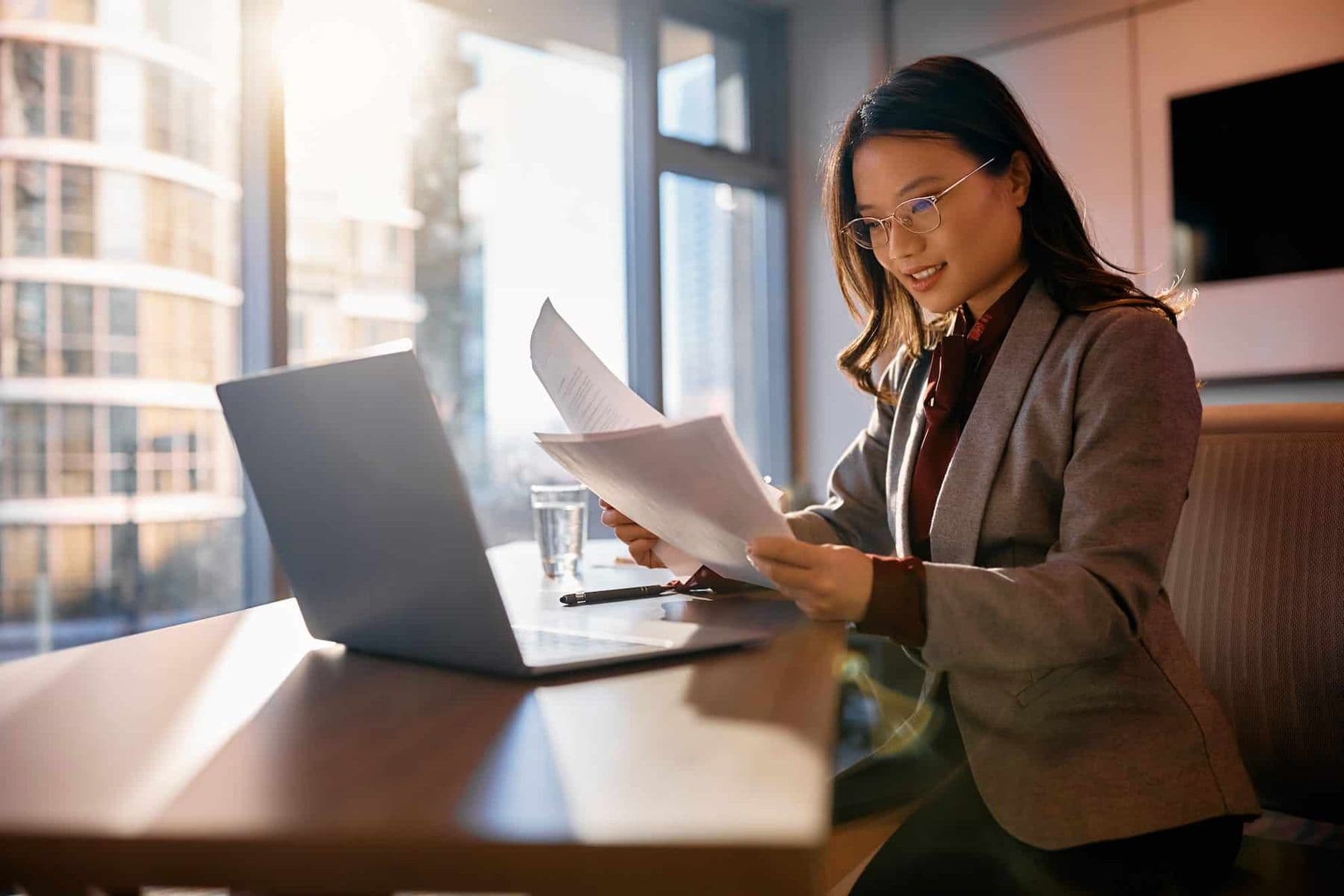 A woman sitting at a desk assessing withholding tax in the UAE in her Dubai office.