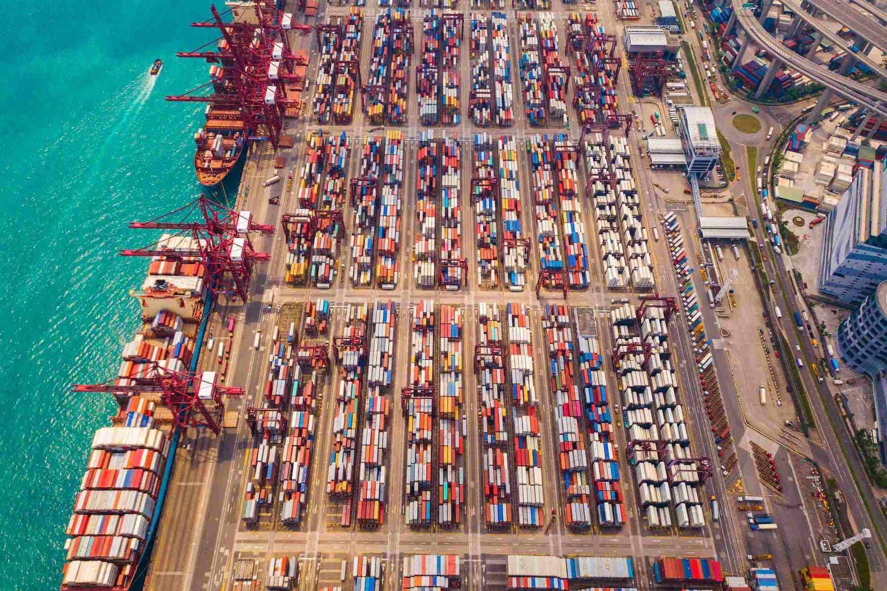 Aerial view of international cargo shipping port with container vessels, representing export of goods and zero rated supplies in the UAE.